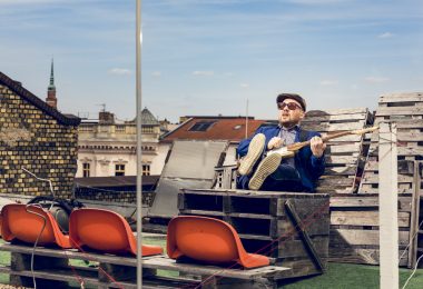 Yuriy-Gurzhy spielt Gitarre auf dem Dach